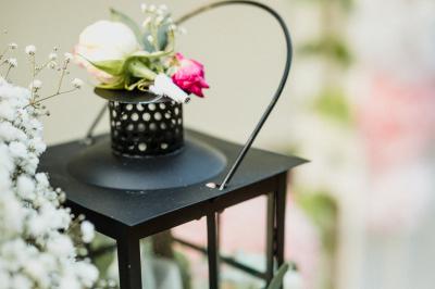 Salle de réception lumineuse avec des tables rondes dressées, nappes blanches et chaises rouges.