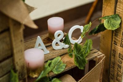 Salle de réception lumineuse avec des tables rondes dressées, nappes blanches et chaises rouges.