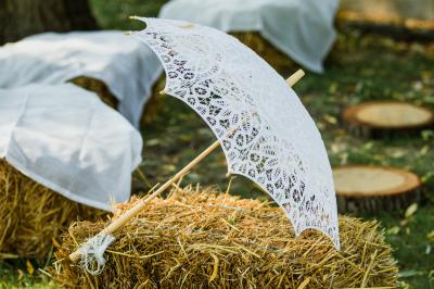 Salle de réception lumineuse avec des tables rondes dressées, nappes blanches et chaises rouges.