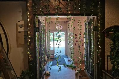 Salle de réception lumineuse avec des tables rondes dressées, nappes blanches et chaises rouges.