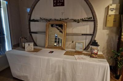 Salle de réception lumineuse avec des tables rondes dressées, nappes blanches et chaises rouges.