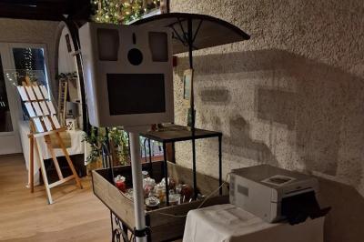Salle de réception lumineuse avec des tables rondes dressées, nappes blanches et chaises rouges.