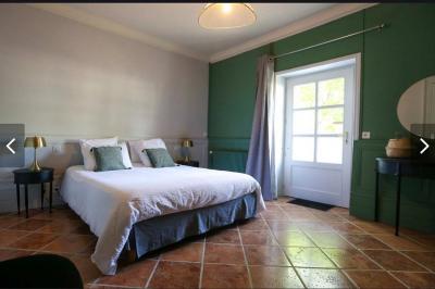 Façade d'un château avec une tour centrale et des fenêtres, entouré de végétation.