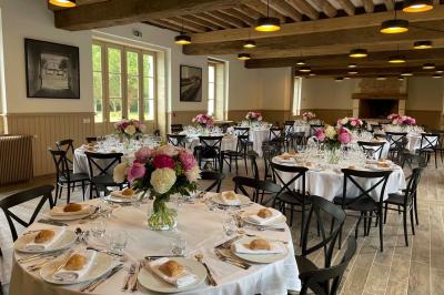 Façade d'un château avec une tour centrale et des fenêtres, entouré de végétation.