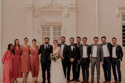 Façade d'un château avec une tour centrale et des fenêtres, entouré de végétation.