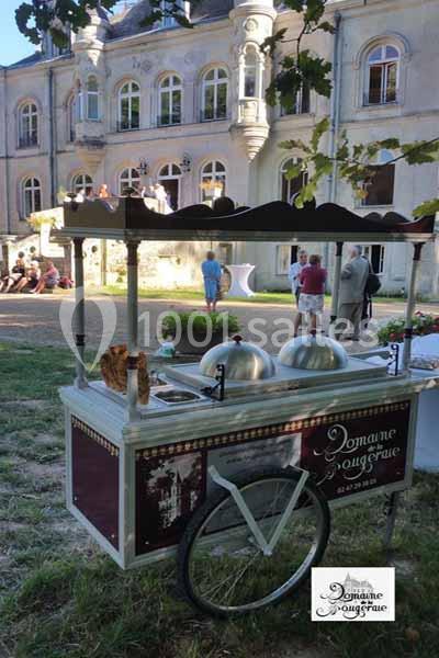 Chariot de glaces devant un château avec des invités rassemblés dans le jardin.