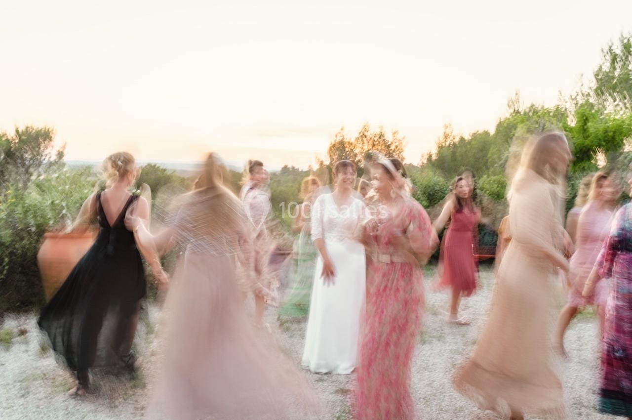 Des personnes dansent en extérieur au coucher du soleil, avec des mouvements flous capturant l'énergie de la scène.