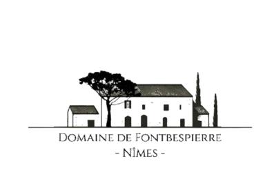 Cour extérieure ensoleillée avec des plantes en pots, des chaises en métal et un bâtiment à toit de tuiles en arrière-plan.