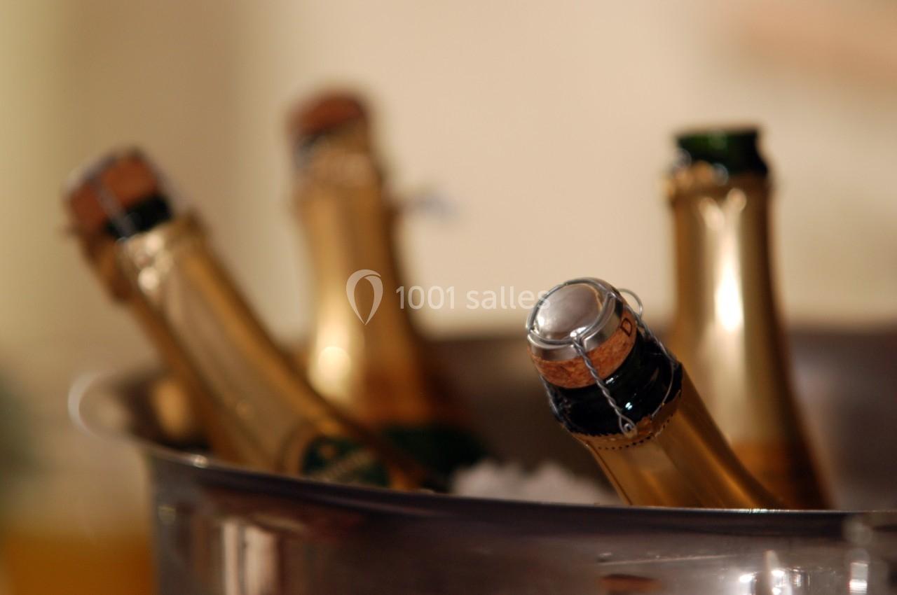 Bouteilles de champagne partiellement immergées dans un seau rempli de glace.