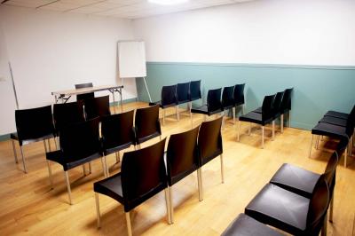 Façade d'un bâtiment avec des enseignes ’MAS’ visibles, situé dans une rue bordée d'immeubles.