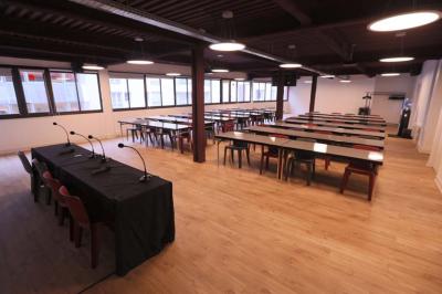 Façade d'un bâtiment avec des enseignes ’MAS’ visibles, situé dans une rue bordée d'immeubles.