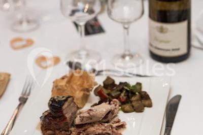 Assortiment de tartinades dans des bols blancs posés sur une rondelle de bois, avec des amuse-bouches en arrière-plan.