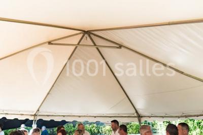 Assortiment de tartinades dans des bols blancs posés sur une rondelle de bois, avec des amuse-bouches en arrière-plan.