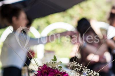 Assortiment de tartinades dans des bols blancs posés sur une rondelle de bois, avec des amuse-bouches en arrière-plan.