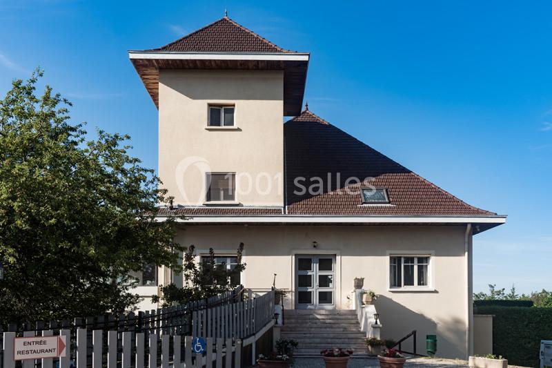 Façade d'un bâtiment avec toit en pente, rampe d'accès et panneau indiquant l'entrée d'un restaurant.