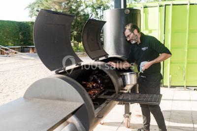 Assortiment de tartinades dans des bols blancs posés sur une rondelle de bois, avec des amuse-bouches en arrière-plan.