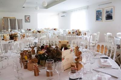 Assortiment de tartinades dans des bols blancs posés sur une rondelle de bois, avec des amuse-bouches en arrière-plan.