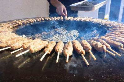 Assortiment de tartinades dans des bols blancs posés sur une rondelle de bois, avec des amuse-bouches en arrière-plan.