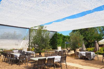 Assortiment de tartinades dans des bols blancs posés sur une rondelle de bois, avec des amuse-bouches en arrière-plan.