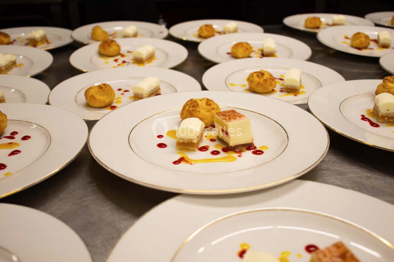 Assiettes dressées avec des desserts variés, incluant des choux, des entremets et des décorations de coulis colorés.