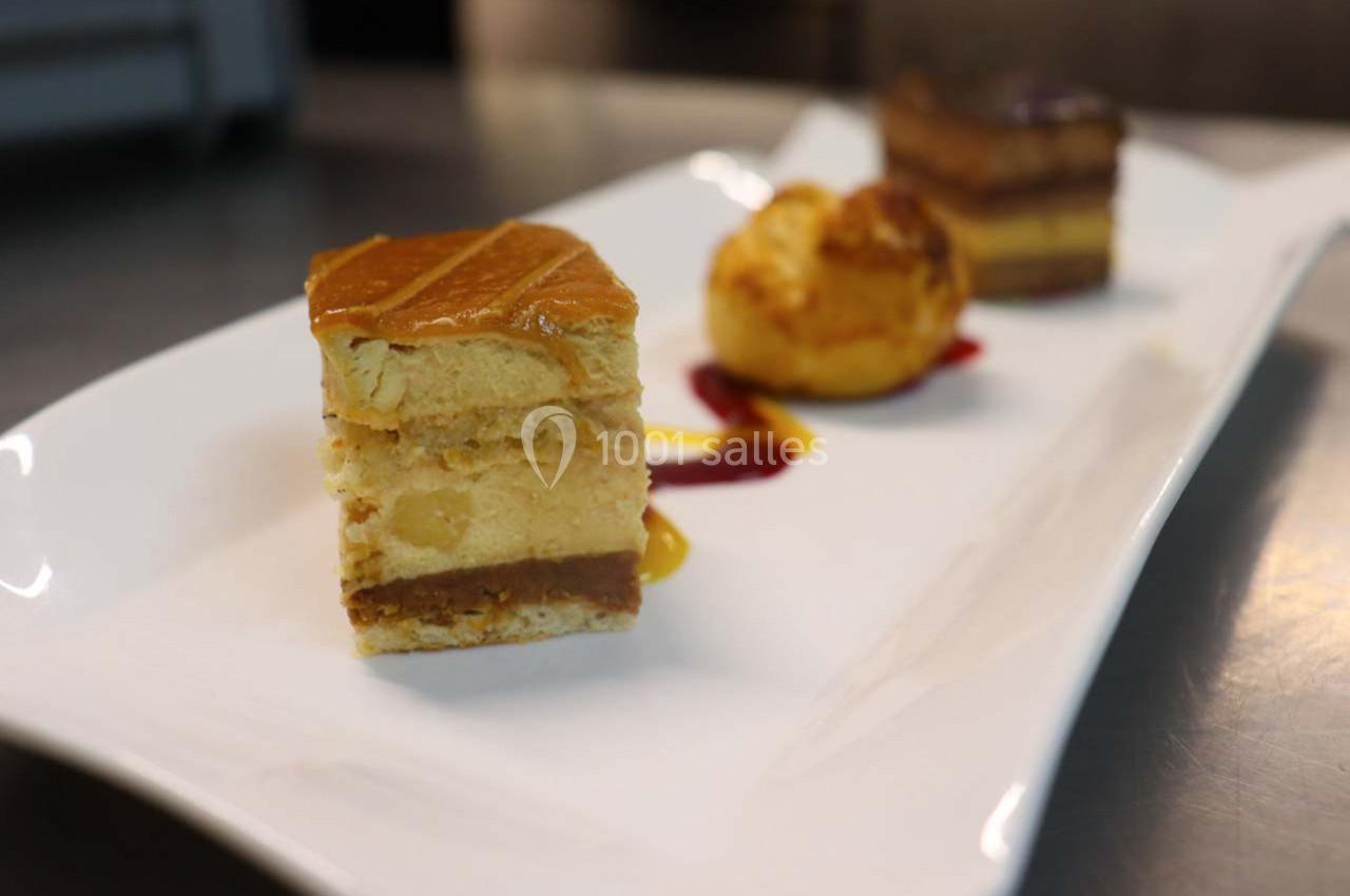 Assortiment de desserts sur une assiette blanche, comprenant un millefeuille, une chouquette et un gâteau au chocolat.