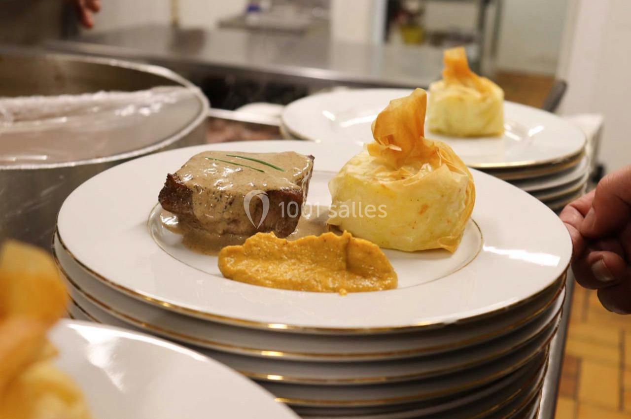 Assiette dressée avec un filet de viande sauce crème, purée et accompagnement en pâte feuilletée.