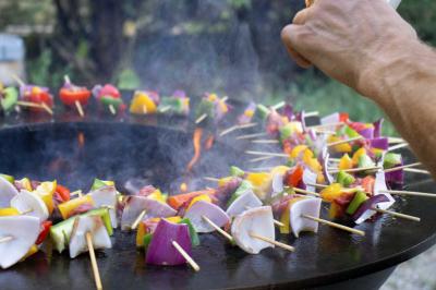 Assortiment de tartinades dans des bols blancs posés sur une rondelle de bois, avec des amuse-bouches en arrière-plan.