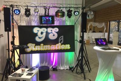 Équipement de sonorisation et éclairage installé pour un événement, avec une bannière ’GS Animation’ en arrière-plan.