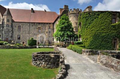 Un groupe de personnes en costumes d'époque chante autour de lutrins dans une salle décorée de style ancien.