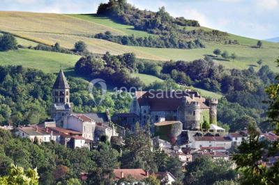 Un groupe de personnes en costumes d'époque chante autour de lutrins dans une salle décorée de style ancien.