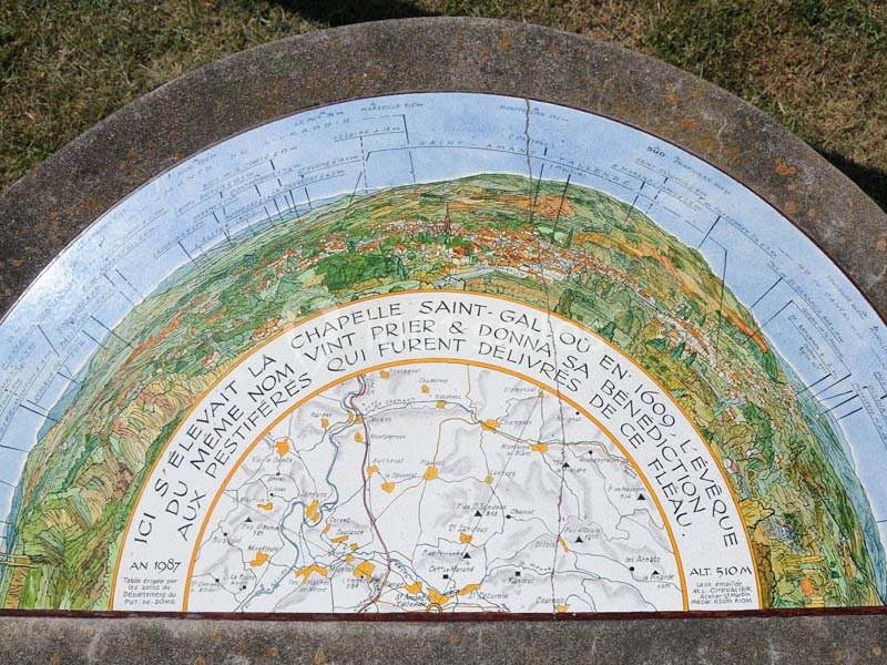 Table d'orientation circulaire illustrant un paysage avec des indications historiques et géographiques.