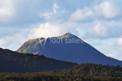 Un groupe de personnes en costumes d'époque chante autour de lutrins dans une salle décorée de style ancien.