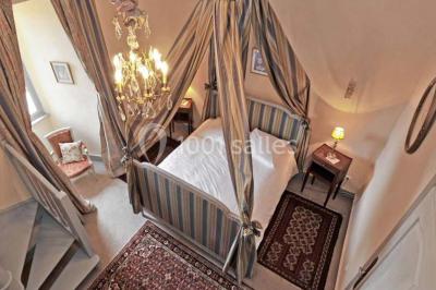 Un groupe de personnes en costumes d'époque chante autour de lutrins dans une salle décorée de style ancien.