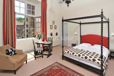 Un groupe de personnes en costumes d'époque chante autour de lutrins dans une salle décorée de style ancien.