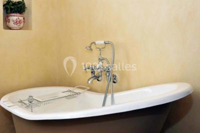 Un groupe de personnes en costumes d'époque chante autour de lutrins dans une salle décorée de style ancien.