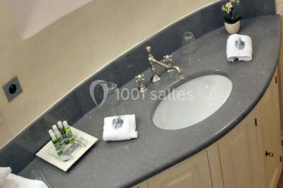 Un groupe de personnes en costumes d'époque chante autour de lutrins dans une salle décorée de style ancien.