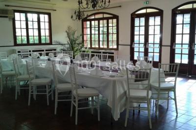 Buffet élégant avec verrines colorées, petits plats variés et décoration florale blanche sur nappes blanches.