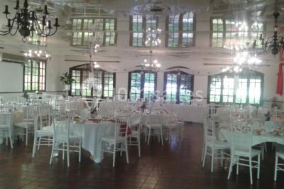 Buffet élégant avec verrines colorées, petits plats variés et décoration florale blanche sur nappes blanches.