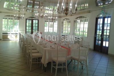 Buffet élégant avec verrines colorées, petits plats variés et décoration florale blanche sur nappes blanches.