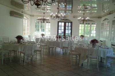 Buffet élégant avec verrines colorées, petits plats variés et décoration florale blanche sur nappes blanches.
