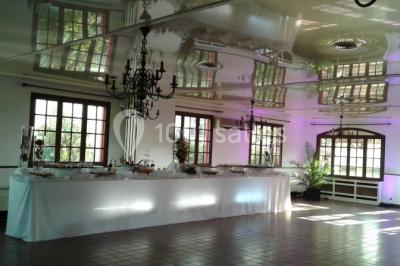 Buffet élégant avec verrines colorées, petits plats variés et décoration florale blanche sur nappes blanches.