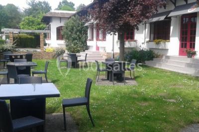Buffet élégant avec verrines colorées, petits plats variés et décoration florale blanche sur nappes blanches.