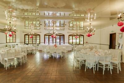 Buffet élégant avec verrines colorées, petits plats variés et décoration florale blanche sur nappes blanches.