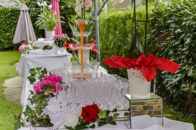 Buffet élégant avec verrines colorées, petits plats variés et décoration florale blanche sur nappes blanches.