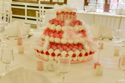 Buffet élégant avec verrines colorées, petits plats variés et décoration florale blanche sur nappes blanches.