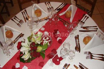 Buffet élégant avec verrines colorées, petits plats variés et décoration florale blanche sur nappes blanches.