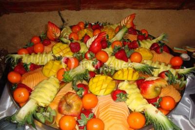 Buffet élégant avec verrines colorées, petits plats variés et décoration florale blanche sur nappes blanches.