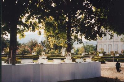 Vue aérienne d'un domaine avec jardins symétriques, bâtiments en pierre, piscine et espaces verts environnants.