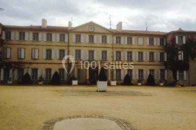Vue aérienne d'un domaine avec jardins symétriques, bâtiments en pierre, piscine et espaces verts environnants.
