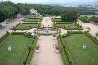 Vue aérienne d'un domaine avec jardins symétriques, bâtiments en pierre, piscine et espaces verts environnants.
